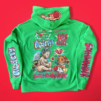 Hoodie hijau cerah dengan motif kartun warna-warni dan grafis di bagian lengan dengan latar belakang merah di studio untuk fashion streetwear yang menyenangkan