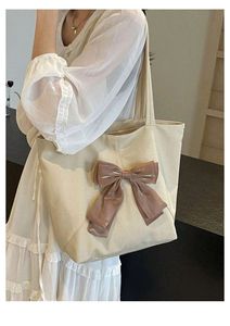 Sac fourre-tout minimaliste en toile poly crème avec un grand nœud nude, conçu pour un port féminin à l'épaule pour un usage quotidien - Product Image 3