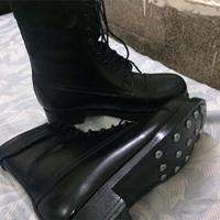 une paire de bottes en cuir noir, peut-être des bottes de pilote ou de pilote de ligne