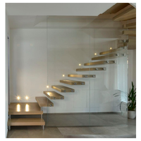 Escalier flottant moderne en bois massif avec poutre en acier dissimulée dans le mur et rampe en verre pour appartement