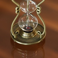 Sa présence métallique remplit la pièce d'une autorité silencieuse, attirant l'attention sans un seul son, un magnifique sablier.