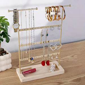 Expositor de joyería rectangular de metal dorado con parte superior ondulada y bandeja con aspecto de mármol blanco disponible a precios de mayorista - Product Image 1