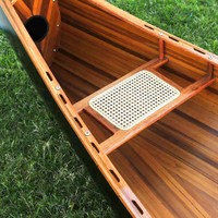 Canoë gonflable artisanal en fibre de verre et bois avec finition teintée foncée, durable et résistant à l'eau, pour 4 pagaillards, adapté aux lacs et rivières.