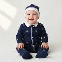 Pyjama bébé tricoté sur mesure bleu marine avec chaussons intégrés, fermeture à boutons-pression et bonnet brodé bateau à voile unique