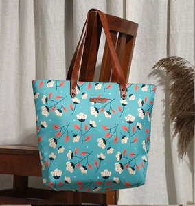 Sac fourre-tout à motif floral turquoise avec poignées en cuir brun. Lumineux et aéré, disponible à prix de gros. - Product Image 1