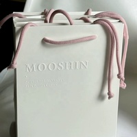 Sac de shopping en papier gaufré de luxe personnalisé avec poignées en corde pour l'emballage de vêtements et de cadeaux de marques de détail