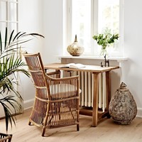 Fauteuil en rotin naturel artisanal avec un design élégant à dossier haut et un coussin moelleux pour salon et villa
