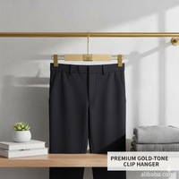 Cintres de luxe en bois entièrement floqués avec tête recouverte de cuir et pinces dorées champagne pour boutiques et salles d'exposition