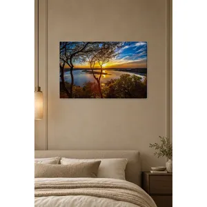 Impresión en lienzo de Fida: Atardecer a través de árboles sobre un lago - Product Image 1