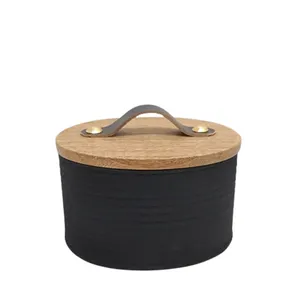 Contenitore in ferro con coperchio in legno e manico in pelle struttura nera opaca e contenitore per alimenti di colore naturale
