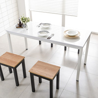 Table à manger moderne au design industriel avec plateau en verre et base en métal réglable en hauteur pour la salle à manger