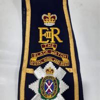 C'est une écharpe de majordome de la Black Watch des Highlands Royales, brodée à la main, en tissu bleu avec une bordure dorée.