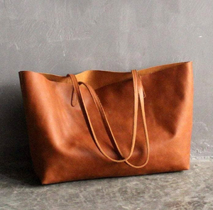 The simple light brown leather slouchy tote near a rough marble coaster is now available at wholesale prices. - Product Image 4