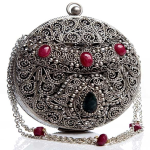 Embrague de metal plateado oxidado con detalles de filigrana y piedras preciosas de color rojo rubí ovalado. Disponible a precio mayorista. - Product Image 1