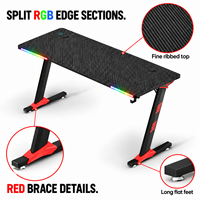 Bureau de jeu noir avec plateau nervuré, accents RGB à l'avant et pieds rouges pour bureaux à domicile, salles d'étude et salles de jeu