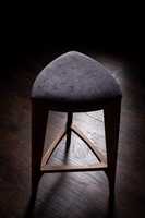Tabouret de bar moderne en bois avec siège rembourré et pied triangulaire robuste, parfait pour la cuisine, le comptoir et la salle à manger.