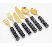 Ensemble d'ustensiles de luxe dorés avec des poignées noires élégantes en forme de bulle pour des dîners raffinés et des présentations de table élégantes