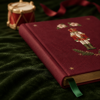 Diario personalizado LABON de Navidad con diseño de Cascanueces, tapa dura color burdeos, estrella dorada bordada, flor rosa y páginas rayadas con motivos de árbol de Navidad.
