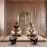 Présentation du mobilier de salon de luxe du Qatar : fauteuil de pédicure crème, bassin pour les pieds ambré, mur en pierre brute et bureau ondulé pour institut de beauté