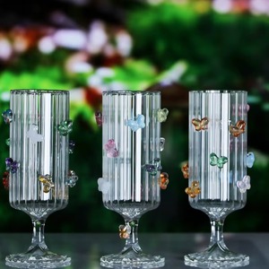 La transparencia de una copa de vino de cristal con un detalle de mariposa crea un contraste visualmente atractivo contra los vinos de colores intensos. - Product Image 2