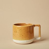 Taza de cerámica brillante con patrón en relieve y borde refinado, ideal para bebidas de desayuno o exhibición de estantes