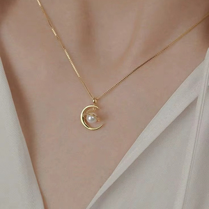 Delicado colgante de luna creciente dorada y perla, disponible a precios de mayoreo. - Product Image 1