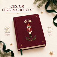 Diario personalizado LABON de Navidad con diseño de Cascanueces, tapa dura color burdeos, estrella dorada bordada, flor rosa y páginas rayadas con motivos de árbol de Navidad.