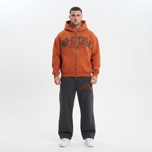 Ensemble de survêtement pour homme en deux pièces : sweat-shirt à capuche orange personnalisé avec fermeture éclair et pantalon de survêtement noir à jambes larges - Product Image 1