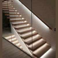 Escalier flottant hybride préfabriqué combinant un poutre centrale en bois massif avec des marches en porte-à-faux des deux côtés.