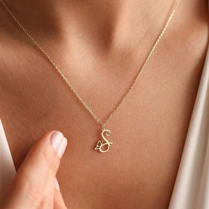 Elegante colgante con inicial de 'S' y una delicada mariposa. Disponible a precios de mayoreo. Personaliza tu estilo hoy - Product Image 1
