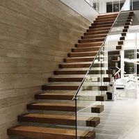 Escalier flottant sur mesure de conception architecturale, construit à partir de marches en bois et d'un garde-corps minimaliste en acier inoxydable