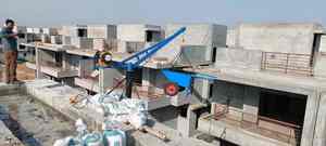 Elevación de materiales de construcción en azoteas utilizando una minigrúa eléctrica con carro mezclador de hormigón en un proyecto de construcción residencial. - Product Image 3
