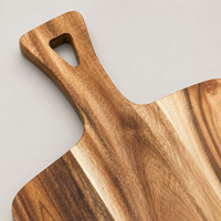 Planche à pain rectangulaire longue en bois d'acacia rustique avec poignée triangulaire découpée pour la cuisine, idéale pour servir du pain au levain artisanal et du fromage