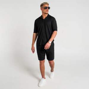 Chemise de coupe décontractée noire fabriquée avec un tissu texturé de qualité supérieure et des accents d'ourlet subtils pour un style décontracté moderne - Product Image 1