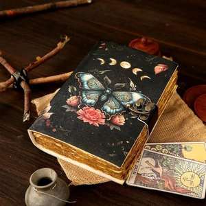 Este diario de cuero hecho a mano presenta una impresionante mariposa en relieve rodeada de flores florecientes y fases lunares que simbolizan - Product Image 1