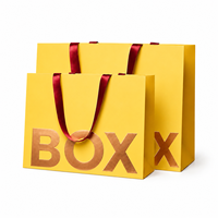 Sacs en papier kraft écologiques en gros, laminés, imprimés sur mesure, emballage de luxe pour la vente au détail, estampage à chaud or, ruban pour vêtements