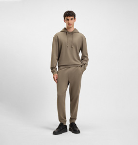 Modelo de ropa masculina minimalista moderna que muestra una sudadera con capucha en tonos neutros y un estilo urbano contemporáneo sin esfuerzo. - Product Image 1