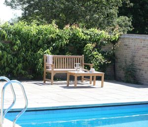 Banc de jardin simple Sarah en bois de teck massif avec coussin imperméable et finition naturelle pour une utilisation en extérieur. - Product Image 3