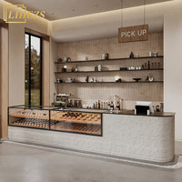 Comptoir de bar à café incurvé en pierre texturée avec vitrine intégrée pour boulangerie, comptoir de réception minimaliste pour café