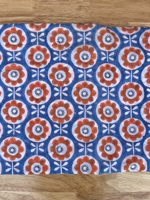 T-shirt pour enfants avec motifs floraux orange et blanc sur fond bleu, créant un design joyeux et ludique, parfait pour tous les jours.