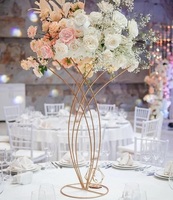Pièce maîtresse de mariage élégante avec une combinaison d'arrangements floraux et de bougeoirs en métal antique pour la décoration