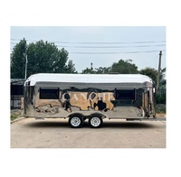 Remolque de caravana resistente equipado con suspensión todoterreno, neumáticos para terrenos difíciles y cocina exterior deslizable.