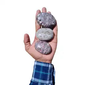 सजावट के लिए ए1 गुणवत्ता वाला हॉट नेचुरल रूबी रायोलाइट पॉलिश किए गए हाथ से नक्काशीदार लोक शिल्प पॉइंट हीलिंग क्रिस्टल पत्थर ताड़ के पत्थर में