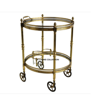 Chariot de rangement pour la cuisine, en acier inoxydable, cadre métallique, couleur or brillant et plateau en verre transparent avec des roues élégantes