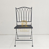 Chaise pliante en fer noir avec dossier arqué gothique pour la location de mobilier de mariage et d'événements