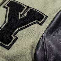 Blouson universitaire femme court en laine vert sauge et noir avec manches en cuir, patch moto en chenille personnalisé