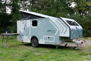 Caravane de luxe pour le camping, dotée d'un lit queen size, d'un coin repas en cuir et d'une salle de bain complète pour les voyageurs. - Product Image 6