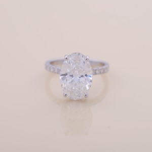 แหวนหมั้นและแต่งงานเพชรทรงรีเพาะเลี้ยงในห้องปฏิบัติการ ได้รับการรับรองจาก IGI พร้อมวงแหวนแบบซ่อน Halo ประดับเพชรในทองคำขาว/โรสโกลด์/ทองคำเหลือง 14K พร้อมแถบ Pavé - Product Image 1