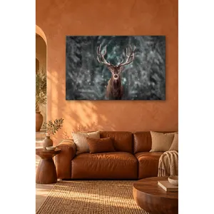 Impression sur toile : Cerf Fida regardant droit en face dans une forêt enneigée - Product Image 1