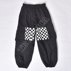 Pantalones Cargo Negros Estilo Urbano con Gráficos de Vinilo Blanco en las Rodillas, Cintura con Cordón, Bolsillos con Cremallera, Ventilaciones y Puños Elásticos - Product Image 1